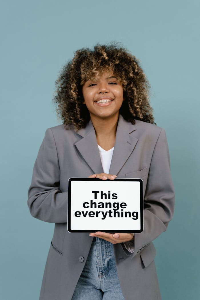 Woman in Gray Blazer Holding White Board